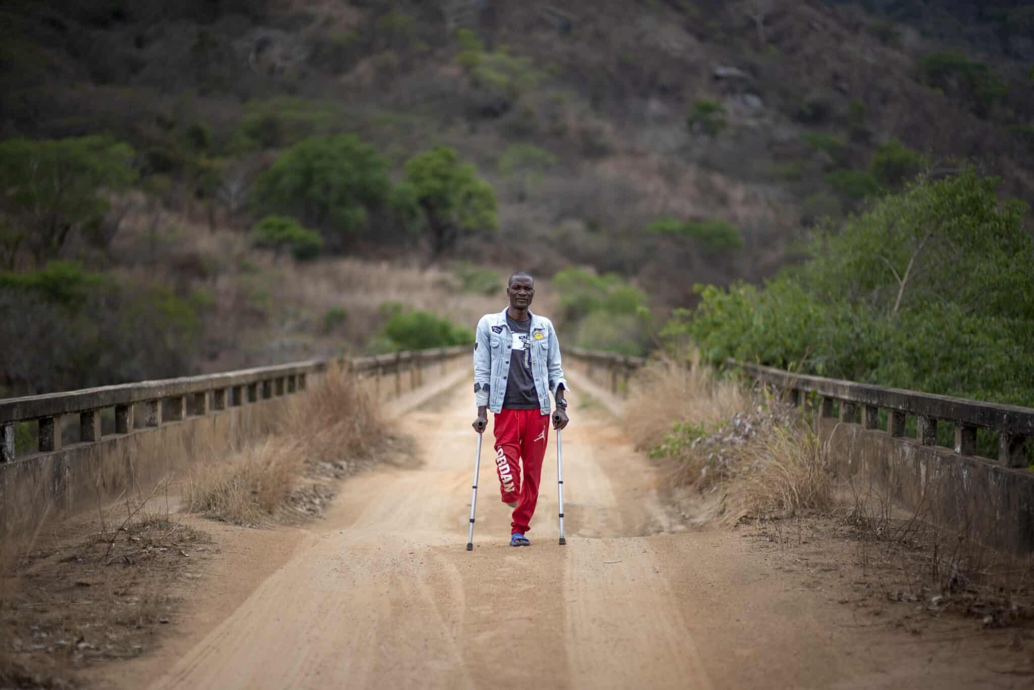 Landmine victim Joao Andre stands on bridge