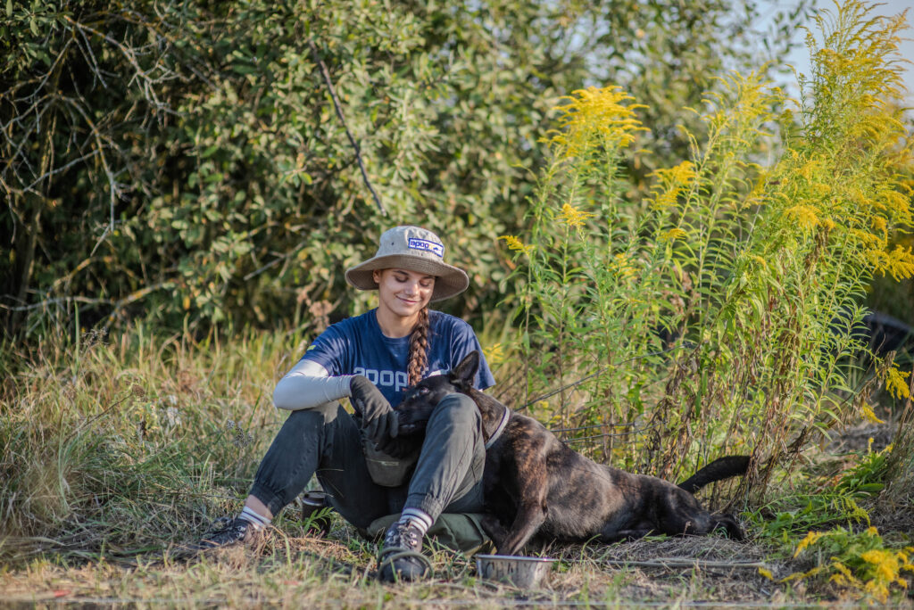 APOPO Dog Handler Daryna in Ukraine shares a restful moment with technical Survey Dog Khai